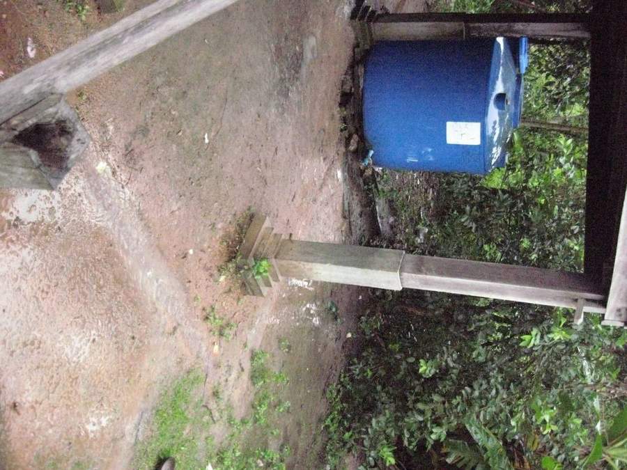 Blue rainwater collection tank on wooden stand