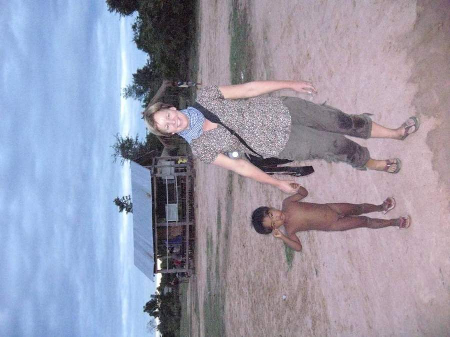 Volunteer standing with child in rural village