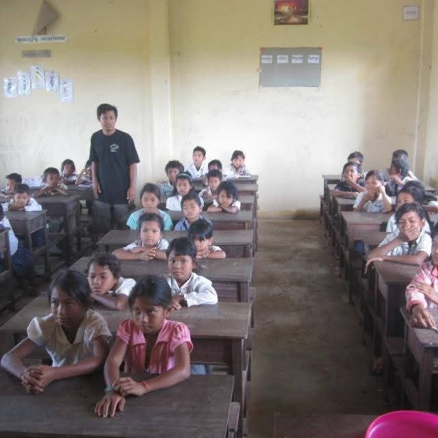 Students seated at desks in classroom with teacher