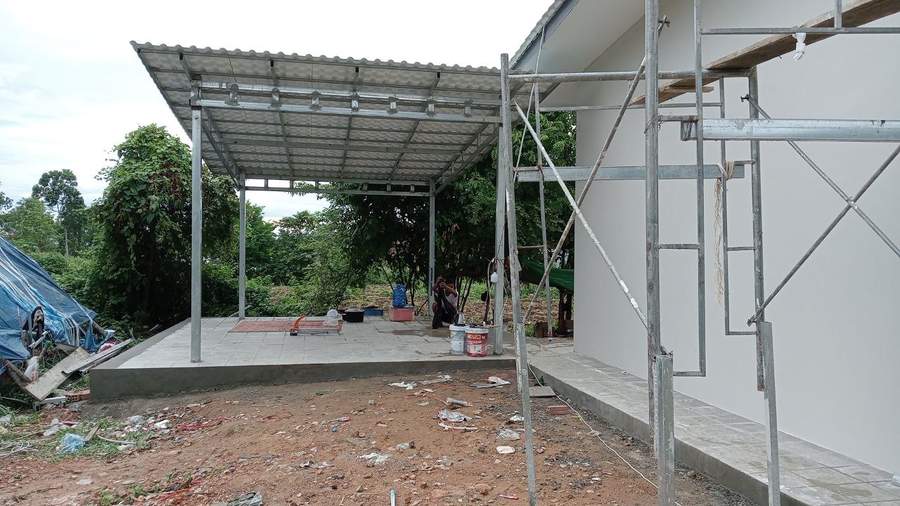 Building under construction with metal roof and scaffolding