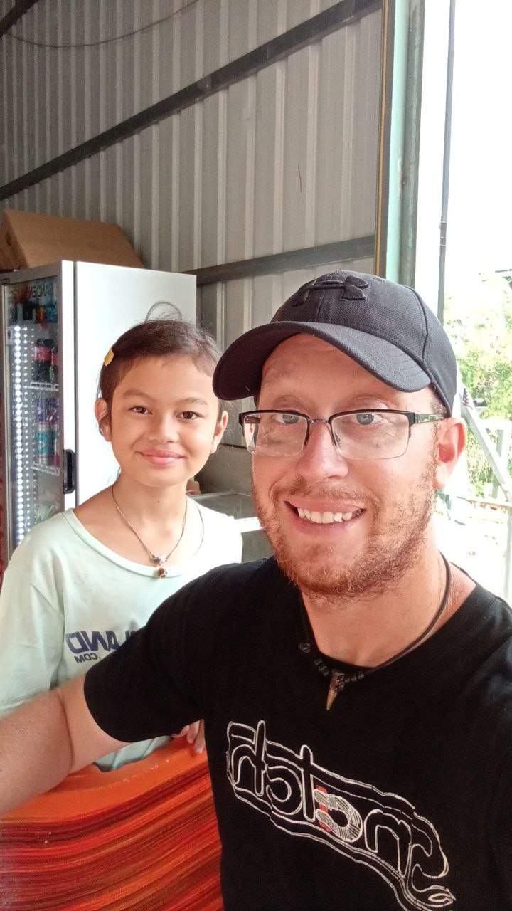 Man and young girl taking selfie at outdoor restaurant