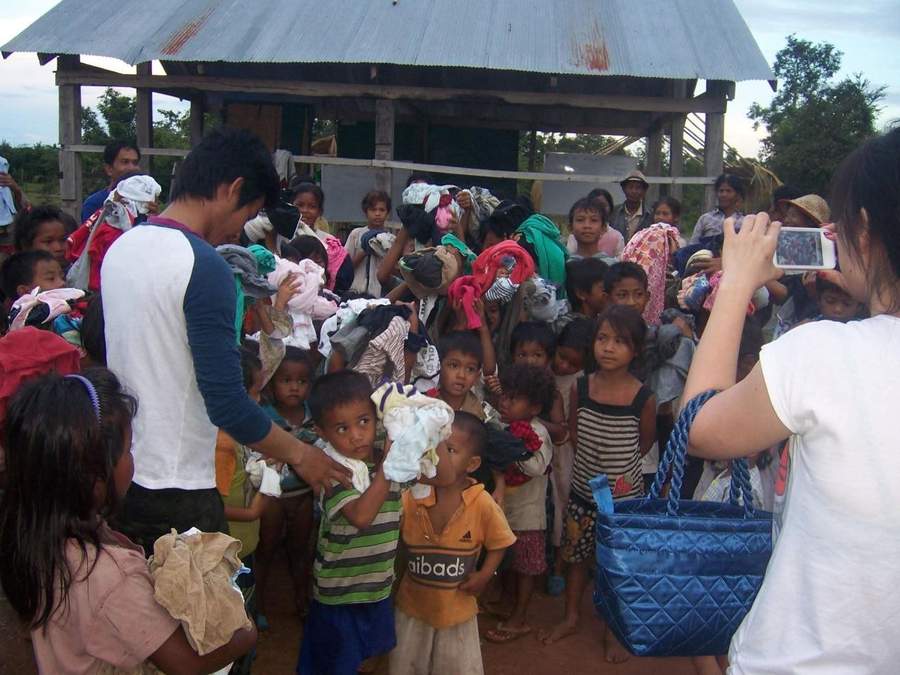 Large group of children receiving donated clothing at school