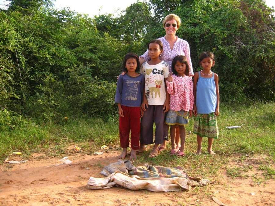 Volunteer woman standing with four young village girls
