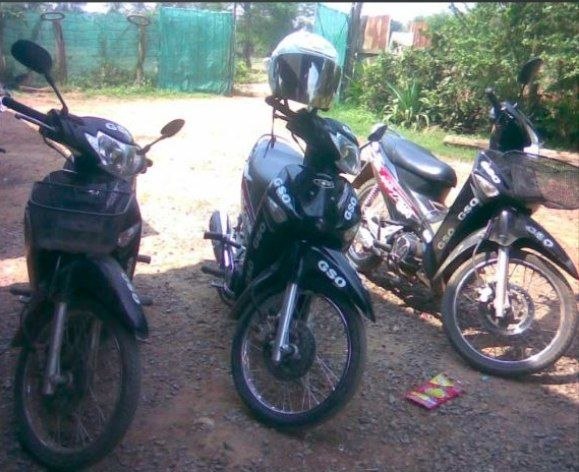Two motorcycles parked on dirt road with GSO stickers