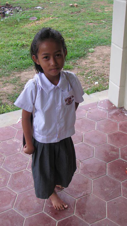 Young girl in white school uniform standing on hexagonal tiles