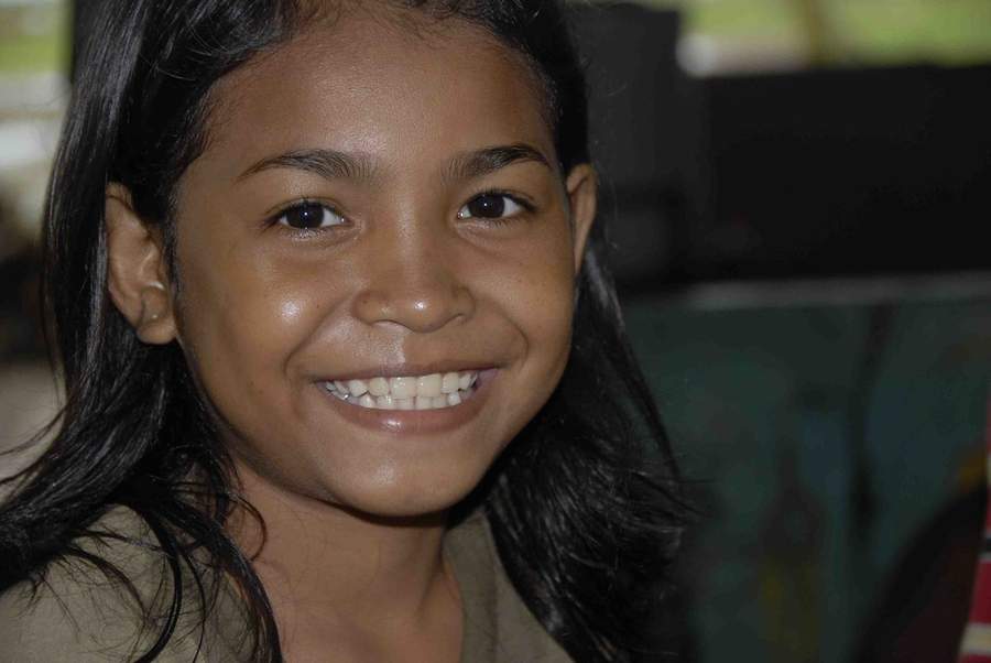 Close-up of smiling young girl with long dark hair