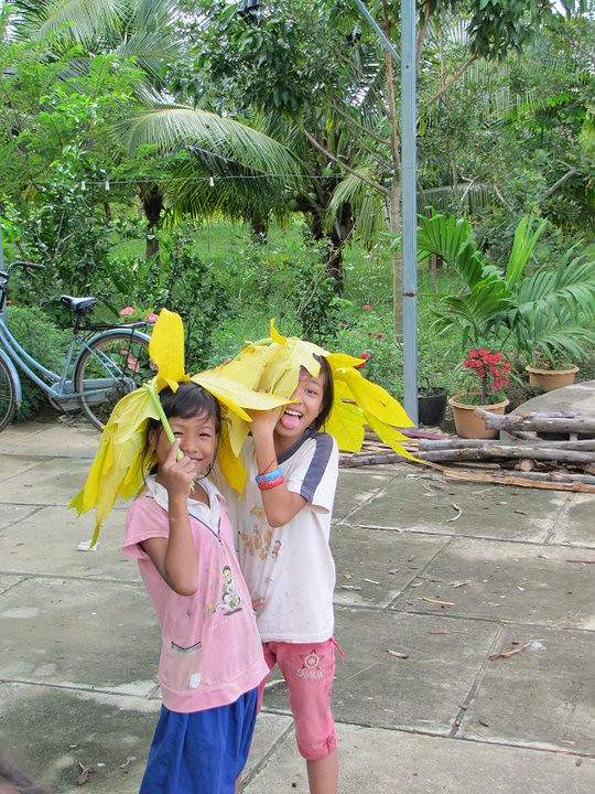 Two girls playing with banana leaves on their heads