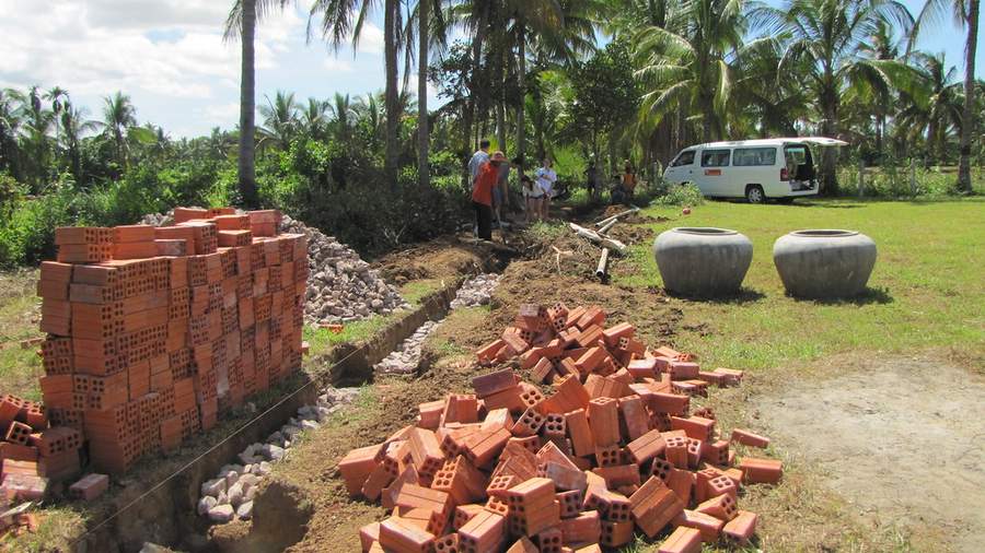 Construction site with stacked bricks and water jars