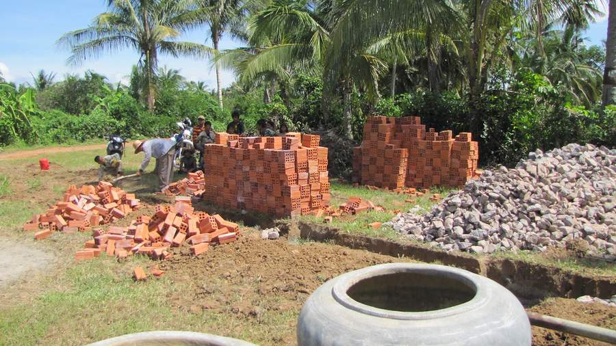 Construction site with brick piles rocks and workers