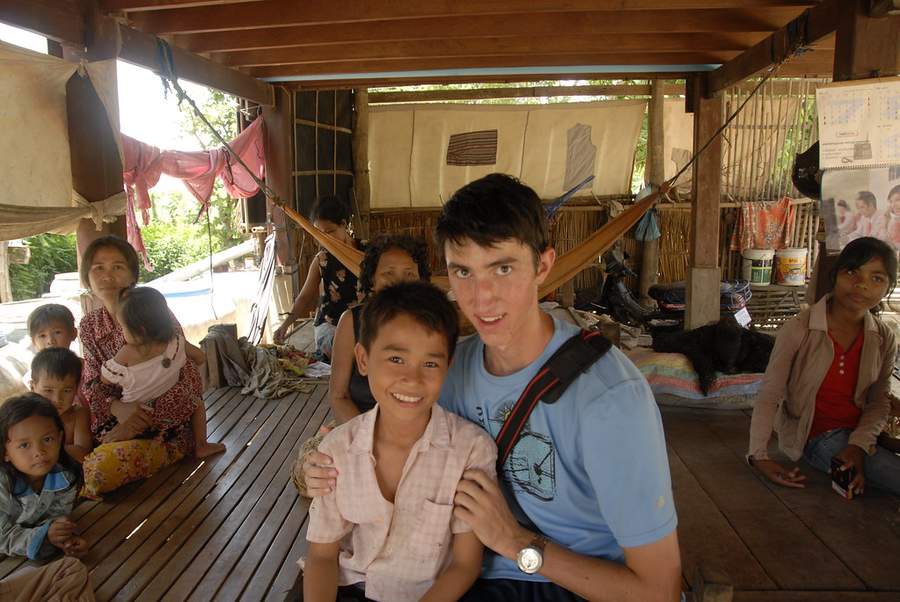 Volunteer with young boy and family in wooden house