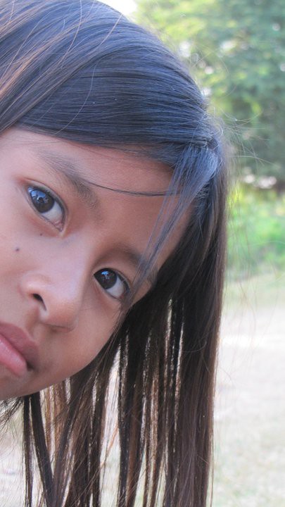 Close-up of young girl with dark hair looking at camera