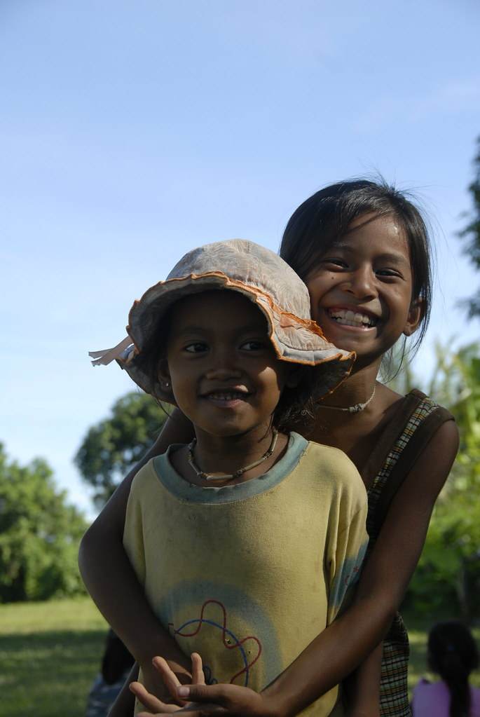 Two girls smiling hugging outdoors