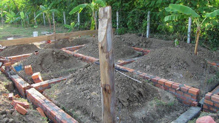 Building foundation under construction with brick walls and dirt piles