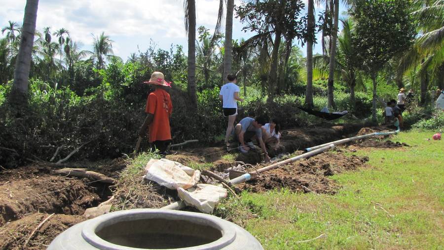 Workers installing pipes in trench at construction site