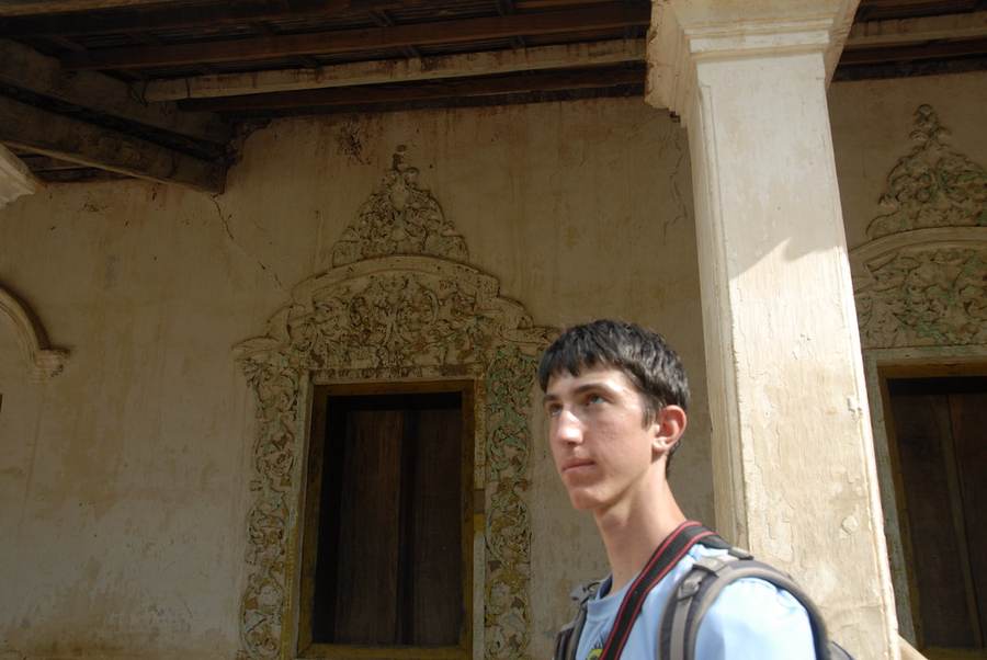 Young man at ornate doorway with carved stone frame